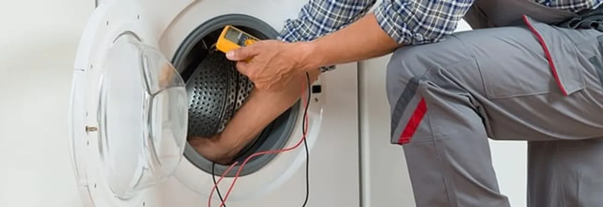 Dryer repair technician inspecting and repairing a clothes dryer in Tacoma, WA