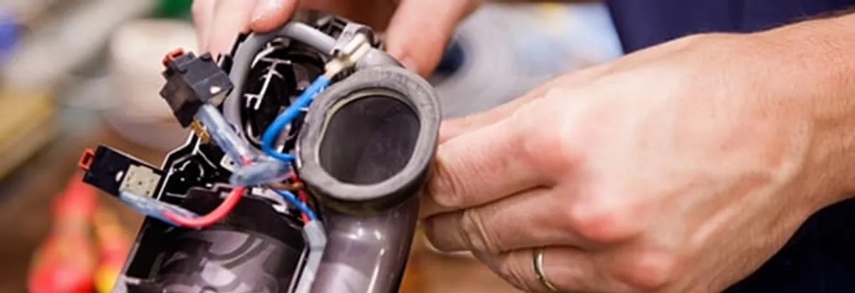 Vacuum repair technician reconnecting wiring and components in Tacoma, WA