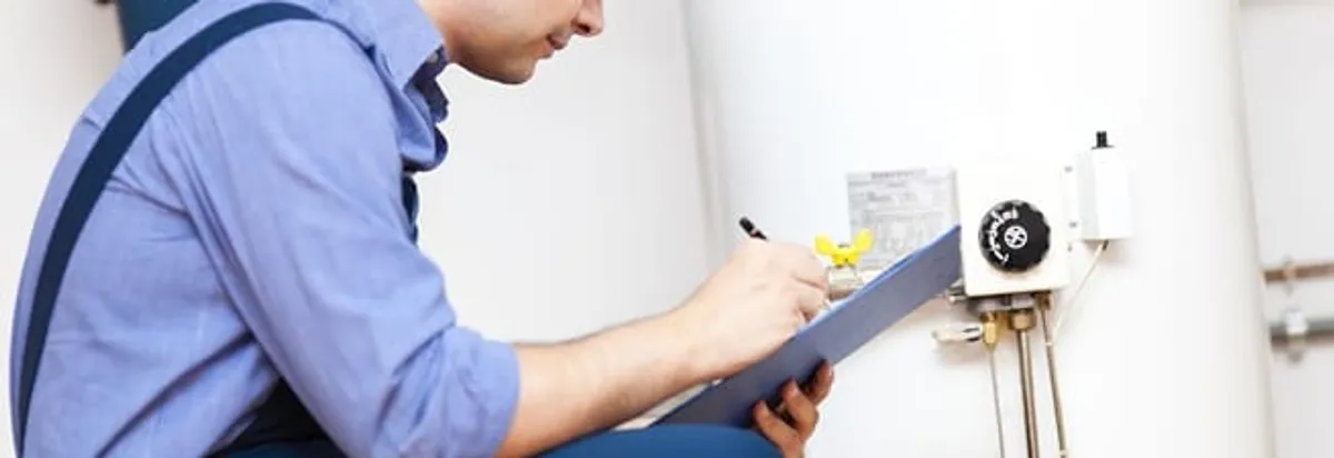 Water heater repair technician inspecting the unit and recording service notes in Tacoma, WA